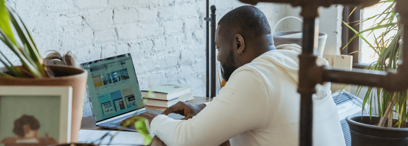 Man sitting at desk looking at a laptop screen