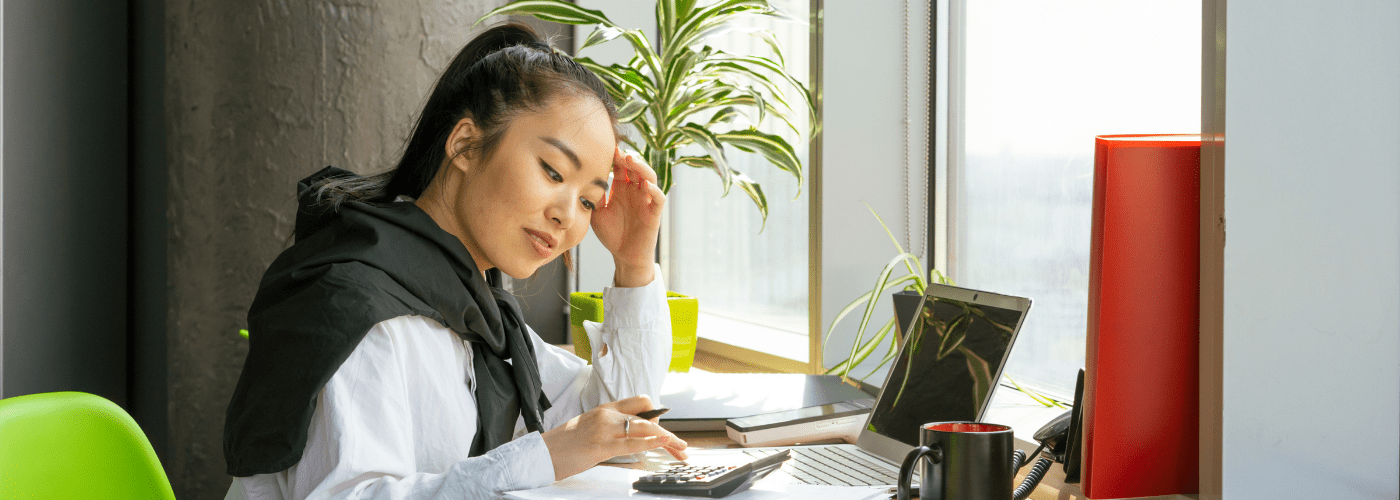 An image of a young woman who looks stressed managing payroll and taxes.